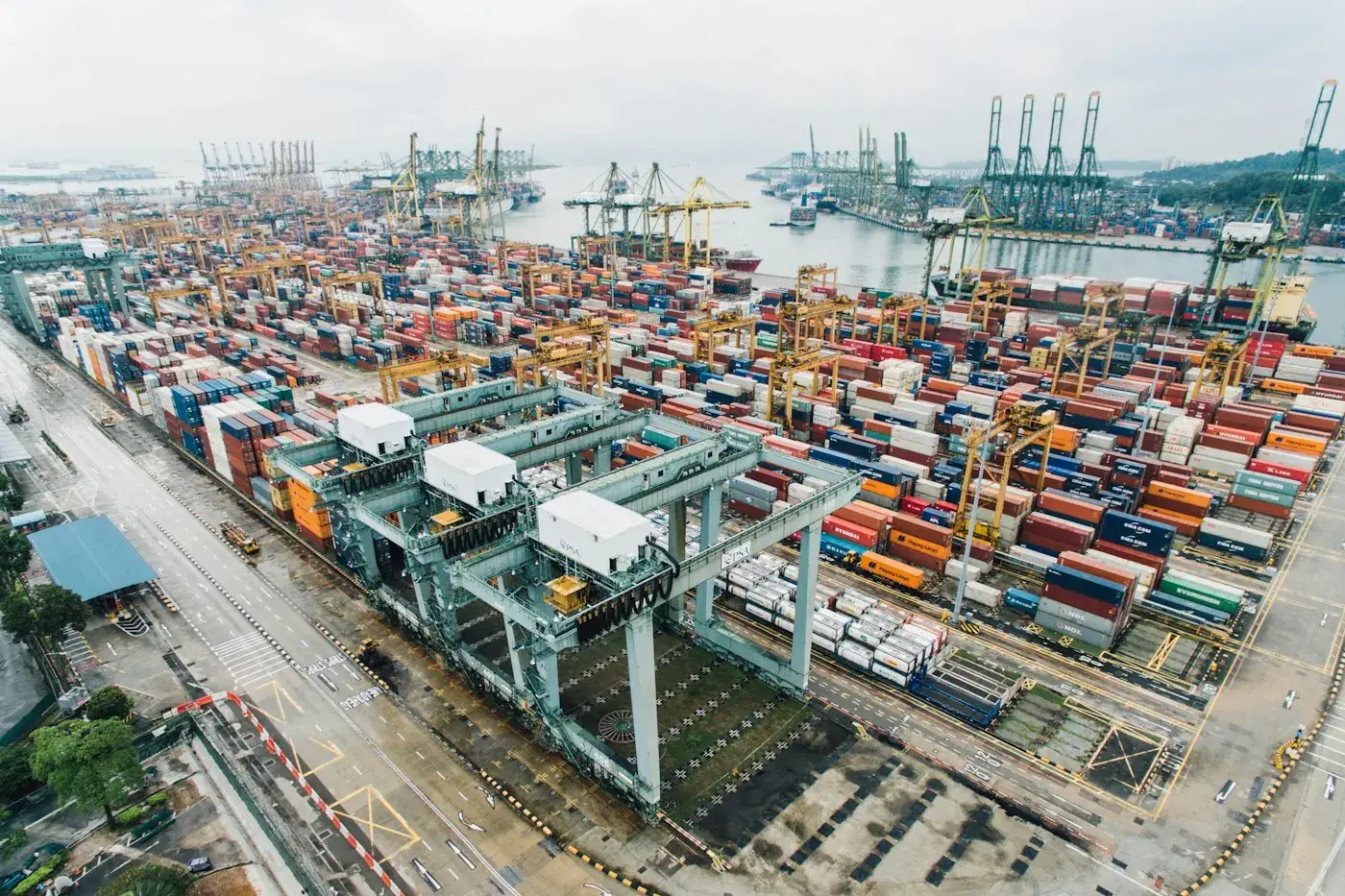 Containerhafen mit Kränen und gestapelten Containern